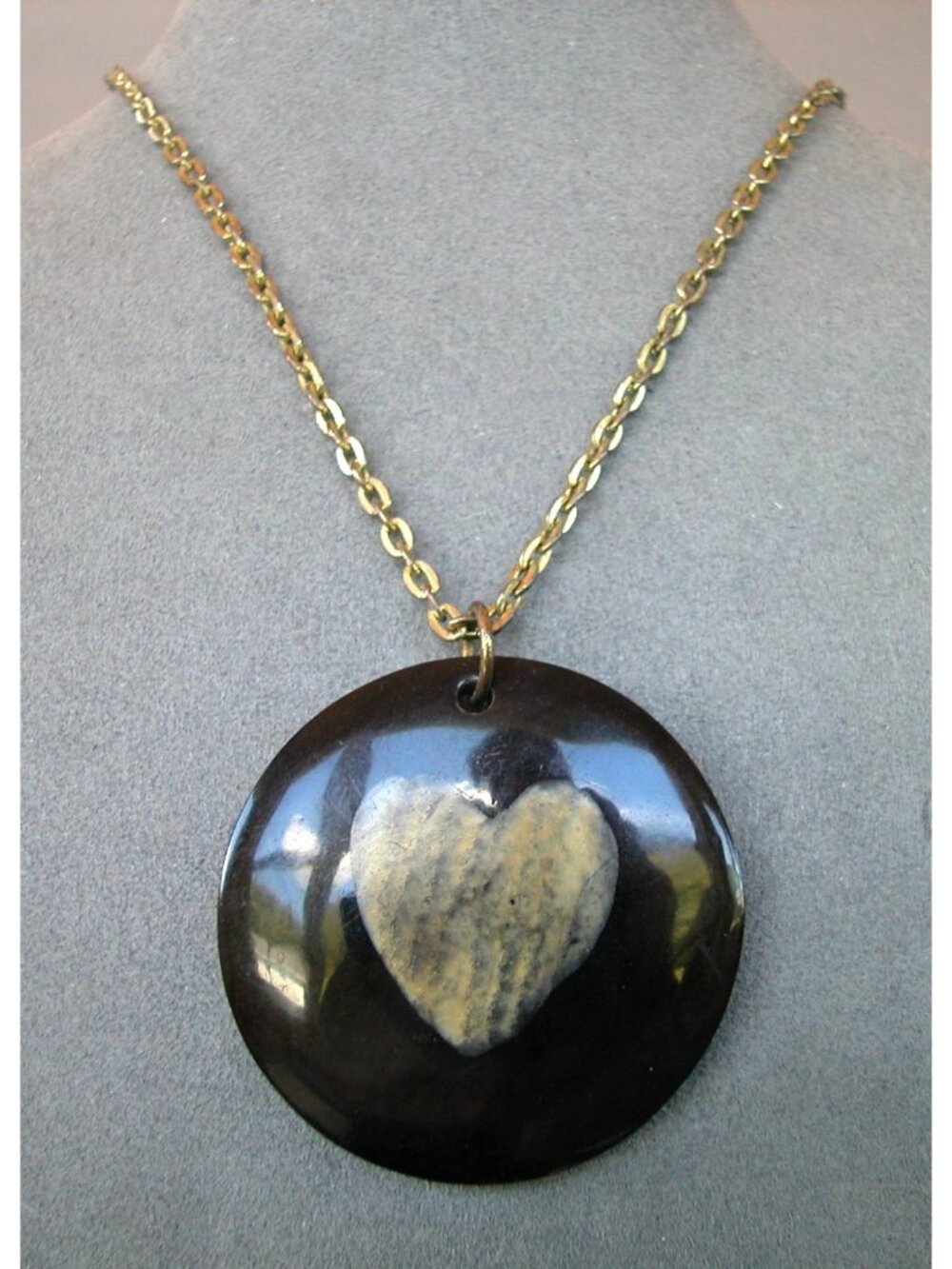 Pendant Necklace with a Polished Dark Circular Disc with a Heart-Shaped Stone